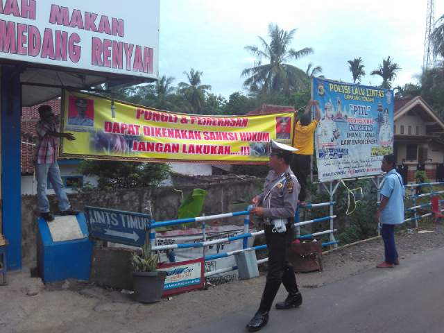 Situasi Anggota Polsek Tebas Sedang Memasang Spanduk Anti Pungli di Sejumlah Ruas jalan Bandarjaya Lamteng,Selasa (28/06).